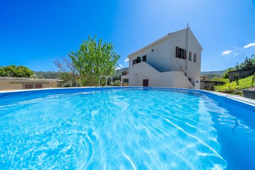 een groot zwembad voor een huis bij Richmond Villa Greece in Póros