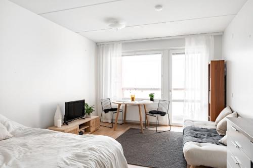 ケラヴァにあるStudio apartment near Kerava train stationの白いベッドルーム(ベッド1台、テーブル、椅子付)