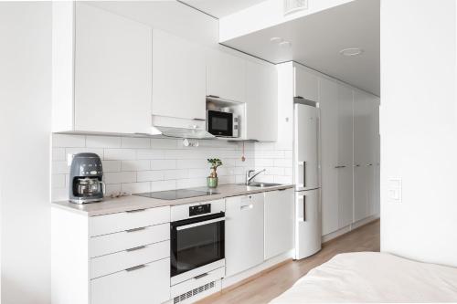 ケラヴァにあるStudio apartment near Kerava train stationの白いキッチン(白いキャビネット、電子レンジ付)