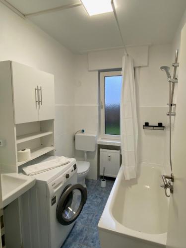 a white bathroom with a toilet and a washing machine at Colleen Homes Monteurwohnung Barntrup Blumenstr 1b in Barntrup