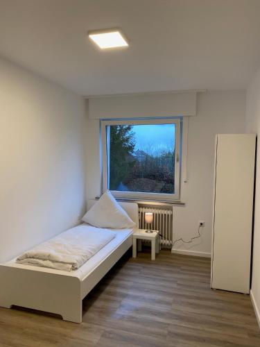 a small bedroom with a bed and a window at Colleen Homes Monteurwohnung Barntrup Blumenstr 1b in Barntrup