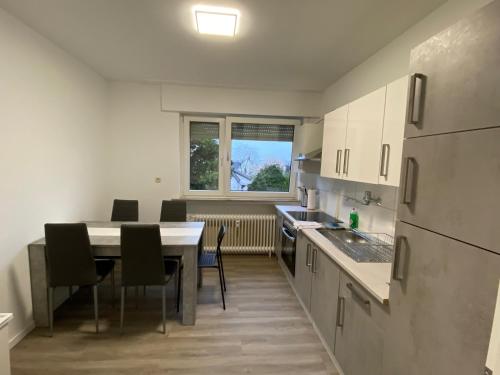 eine Küche mit einem Tisch und Stühlen sowie einem Fenster in der Unterkunft CaJu-Stays Monteurwohnung - Barntrup, Blumenstr. 1b in Barntrup