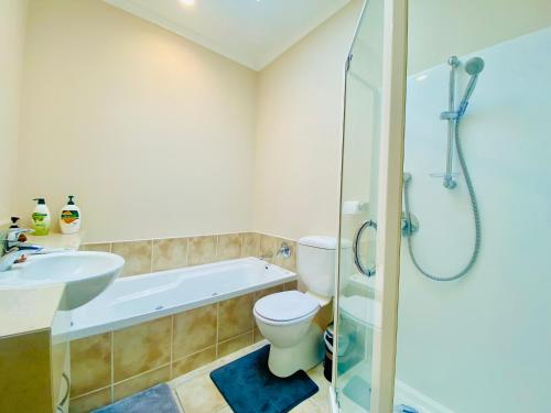 a bathroom with a tub and a toilet and a sink at ROOM IN GREAT SEA VIEW HOUSE in Wellington