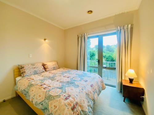 a bedroom with a bed and a large window at ROOM IN GREAT SEA VIEW HOUSE in Wellington