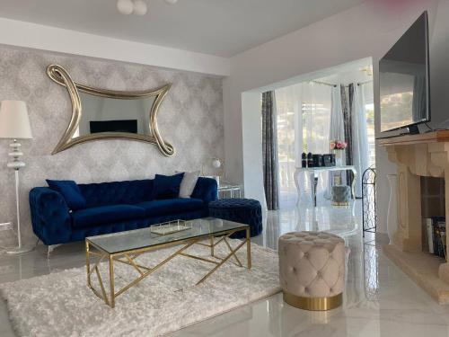 - un salon avec un canapé bleu et un miroir dans l'établissement Villa la Barraca, à Jávea