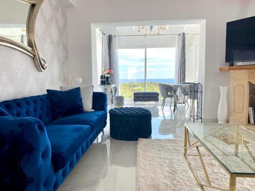 - un salon avec un canapé bleu et une table dans l'établissement Villa la Barraca, à Jávea