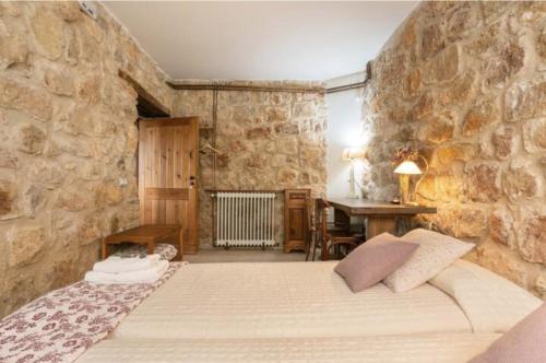 a bedroom with a bed and a stone wall at Mas Coquells Habitación doble de 2 camas in Vilanant