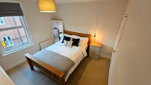 a bedroom with a bed with pillows and a window at City Centre with Hot Tub - 3 Bed in Kent