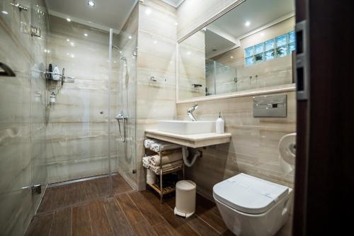 a bathroom with a sink and a toilet and a shower at Apartment Antique Theatre 2 in Stara Zagora