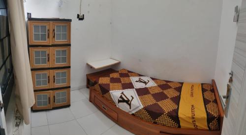 een kleine slaapkamer met een bed in een kamer bij Penginapan Wanita Putri Salju Hostel Semarang in Semarang