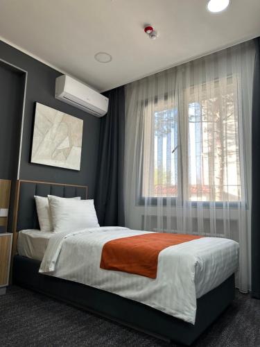 a bedroom with a large bed and a window at Nuovo Boutique Hotel in Tashkent
