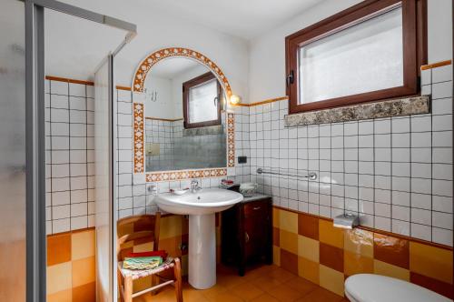 ein Bad mit einem Waschbecken und einem Spiegel in der Unterkunft Casetta del Manco in Corigliano dʼOtranto