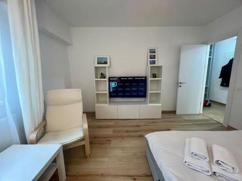 een kamer met een bed, een stoel en een televisie bij Cipariu Corner in Cluj-Napoca