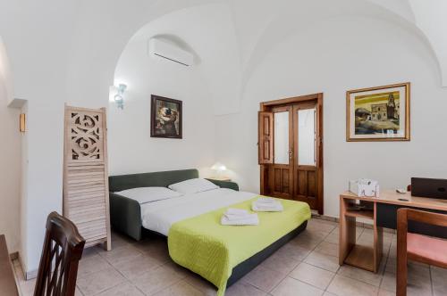 Schlafzimmer mit einem Bett, einem Schreibtisch und einem Tisch in der Unterkunft Casetta del Manco in Corigliano dʼOtranto