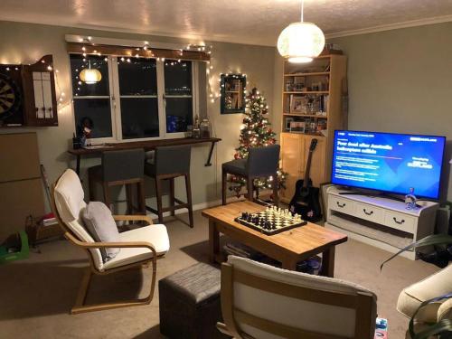a living room with a christmas tree and a television at Lovely riverside flat in Stifford