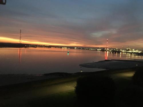 a large body of water with a sunset in the background at Lovely riverside flat in Stifford