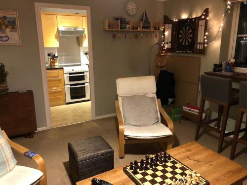 uma sala de estar com um tabuleiro de xadrez sobre uma mesa em Lovely riverside flat em Stifford