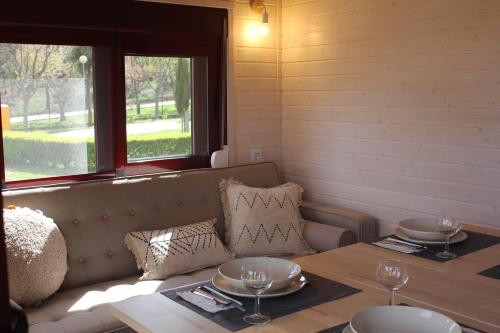 una habitación con un sofá y una mesa con gafas. en Camping Oleiros, en Oleiros