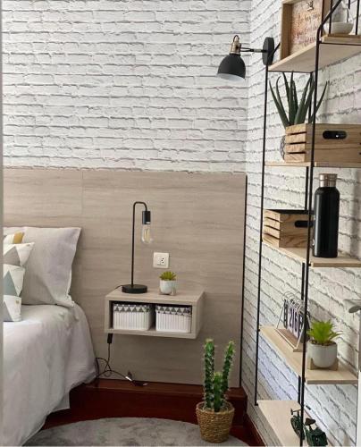 a bedroom with a bed and a white brick wall at LAR DA REVOLTA in Cedeira