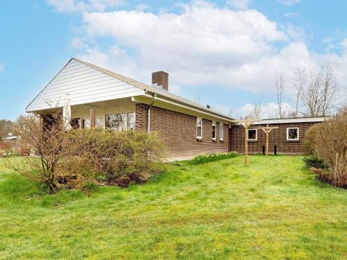 a house with a grass yard in front of it at 5 person holiday home in Thyholm-By Traum in Thyholm