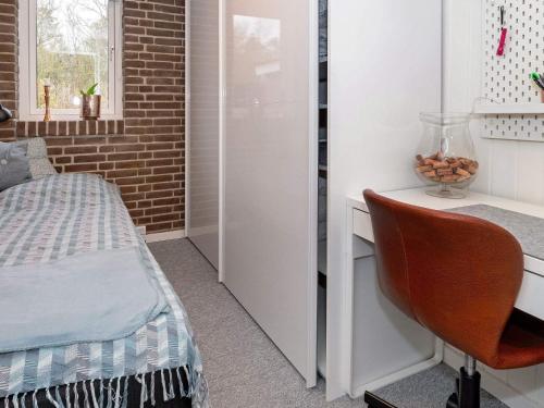 a bedroom with a bed and a desk with a chair at 5 person holiday home in Thyholm-By Traum in Thyholm