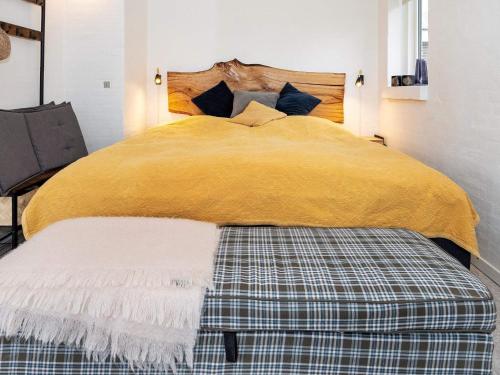 a bedroom with a bed with a yellow blanket at 5 person holiday home in Thyholm-By Traum in Thyholm