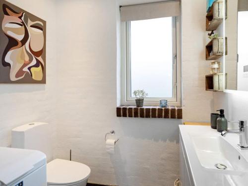 a bathroom with a toilet and a sink and a window at 5 person holiday home in Thyholm-By Traum in Thyholm