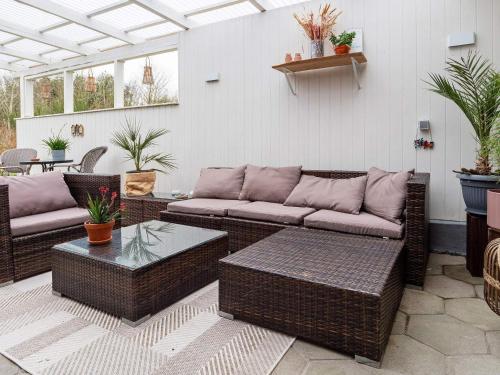 a patio with two wicker couches and a table at 5 person holiday home in Thyholm-By Traum in Thyholm