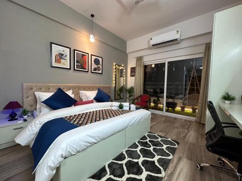 a bedroom with a large bed with blue pillows at Sapphire Skies By BuddiesHome in Greater Noida