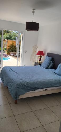 une chambre avec un lit avec une couette bleue dans l'établissement Villa3 chambres, 4-6 personnes 5 minutes de la plage, à Bormes-les-Mimosas