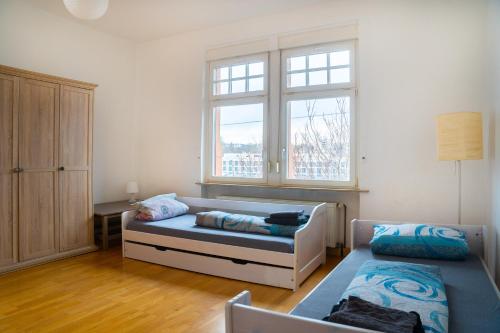 een woonkamer met een bed en een raam bij Mainz Innenstadt 3 Zimmer Altbauwohnung in Mainz