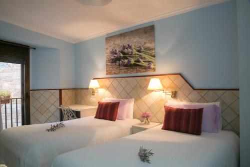 a hotel room with two beds and a painting on the wall at Estudios Casa Lola de Talarn in Talarn