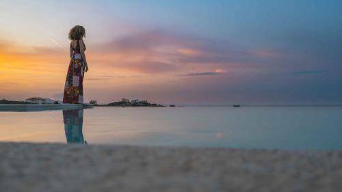 a woman standing on the beach looking at the water at Star Luxury Villa - Private pool, gym, playground in Kato Daratso