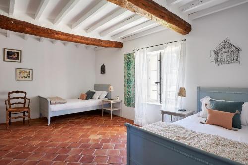a bedroom with two beds and a chair at Château de Berne in Lorgues