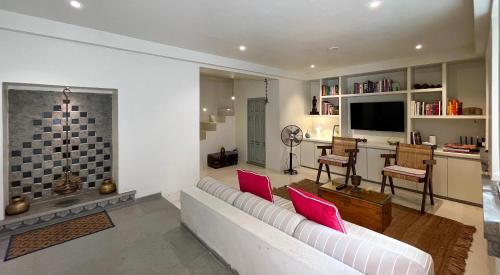 - un salon avec un canapé blanc et des oreillers rouges dans l'établissement Smiling Sparrows 1 and 2 Bedroom Villas, à Udaipur