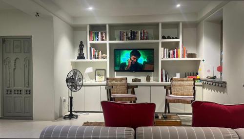 un salon avec une télévision, un canapé et des chaises dans l'établissement Smiling Sparrows 1 and 2 Bedroom Villas, à Udaipur
