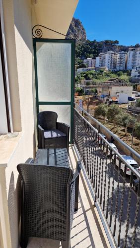 uma varanda com 2 cadeiras de vime e vista para o oceano em RockSea Rooms em Cefalù