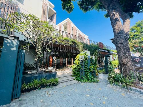 ein Gebäude mit einem Baum und einer Treppe davor in der Unterkunft Glenwood City Resort in Ho-Chi-Minh-Stadt
