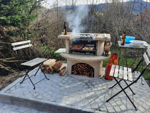 a stone barbecue with a grill and a table at Haus mit Bergblick in Siegsdorf