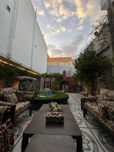 un patio con sofás y una mesa en un patio en استراحة صيفيه بالهدا الطائف en Al Hada