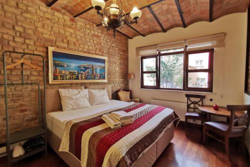 ein Schlafzimmer mit einem großen Bett in einer Ziegelwand in der Unterkunft Ottobalat in Istanbul