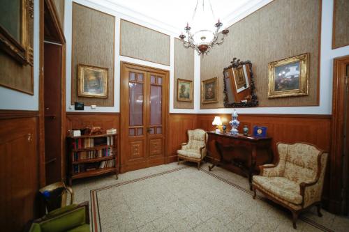 Zimmer mit einem Schreibtisch, 2 Stühlen und einem Kronleuchter in der Unterkunft La casa di Marcello in Catania