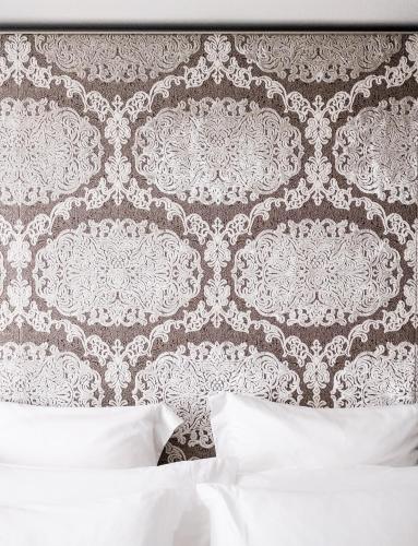 a bedroom with a white bed and a wall at Bvlgari Hotel London in London