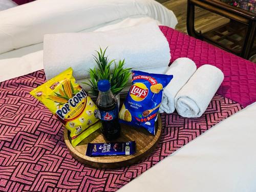 a tray with snacks and drinks on a bed at Sapphire Skies By BuddiesHome in Greater Noida