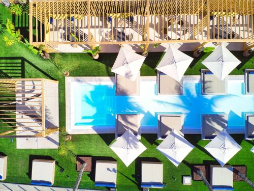 - une vue sur la piscine dotée de tables et de chaises blanches dans l'établissement H10 Costa Mogán, à Playa del Cura