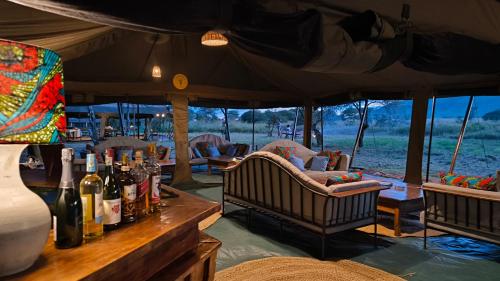 a bar with bottles of wine on a table at Kananga Special Tented Camp in Banagi