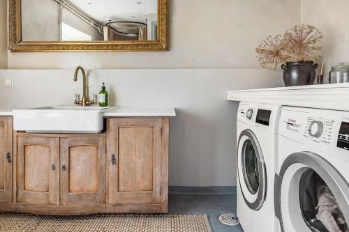 a bathroom with a sink and a washing machine at Large Stylish Charming House With Big Garden in Eskilstuna