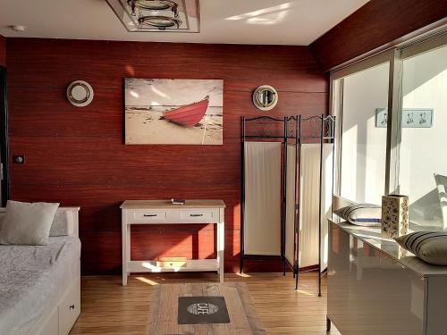- un salon avec un mur rouge et une cheminée dans l'établissement Appartement Saint-Hilaire-de-Riez, 1 pièce, 3 personnes - FR-1-652-14, à Saint-Hilaire-de-Riez