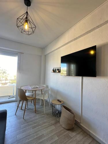 d'une salle à manger avec une table et une télévision murale. dans l'établissement Studio avec vue Mer au pied de la Plage, à Saint-Cyprien