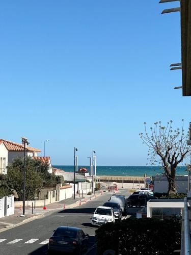 - un parking avec des voitures garées à côté de la plage dans l'établissement Studio avec vue Mer au pied de la Plage, à Saint-Cyprien